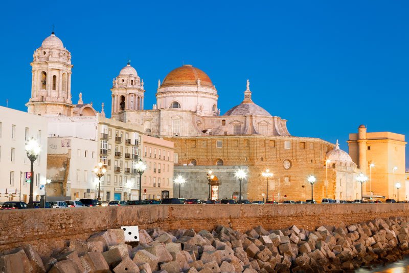 domed cathedral of cadiz and other buildings along sea wall