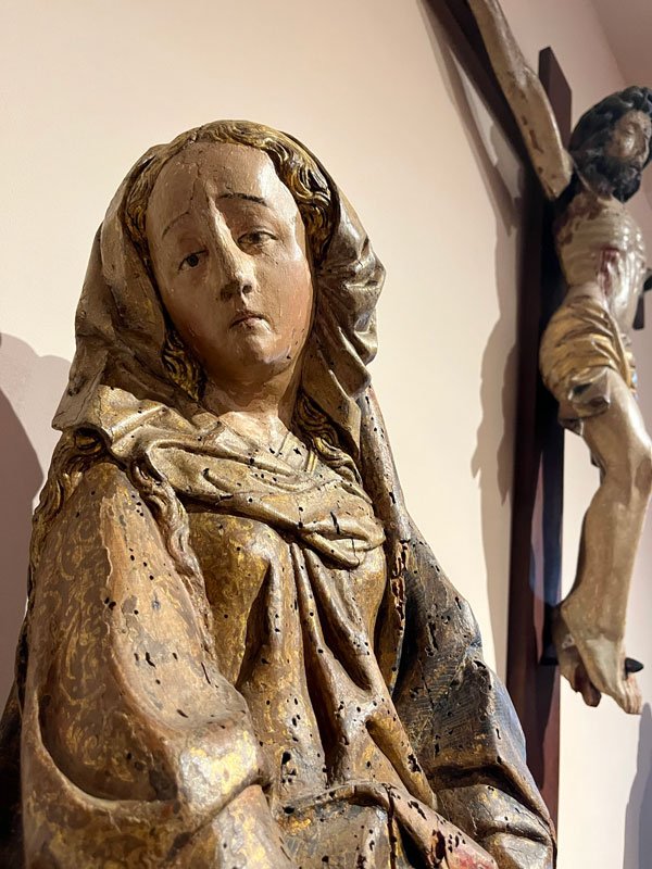 wooden sculptire of mary next to christ on a cross