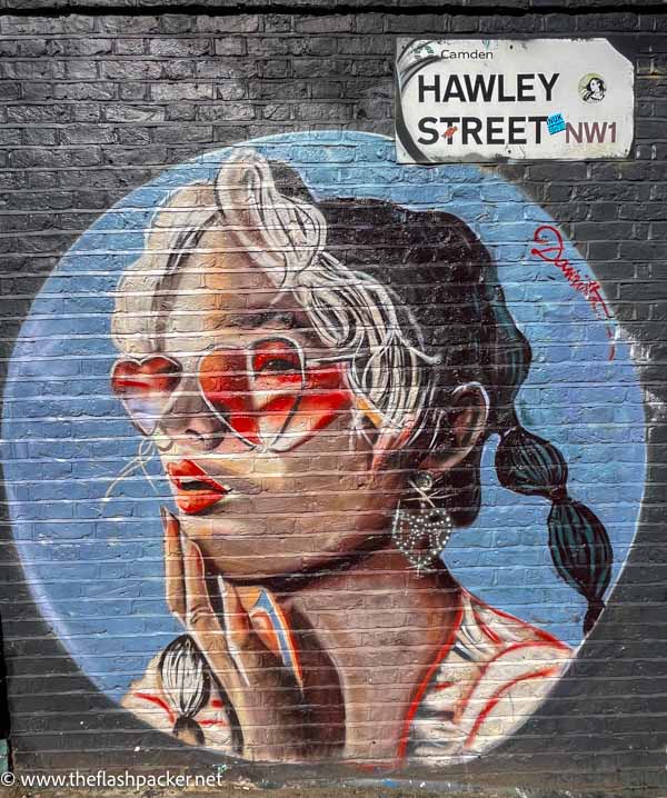 wall mural of a girl wearing heart shaped glasses under a sign saying hawley street