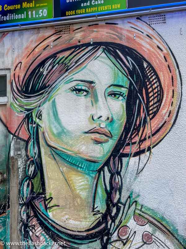 wall mural of a woman wearing a pink sunhat