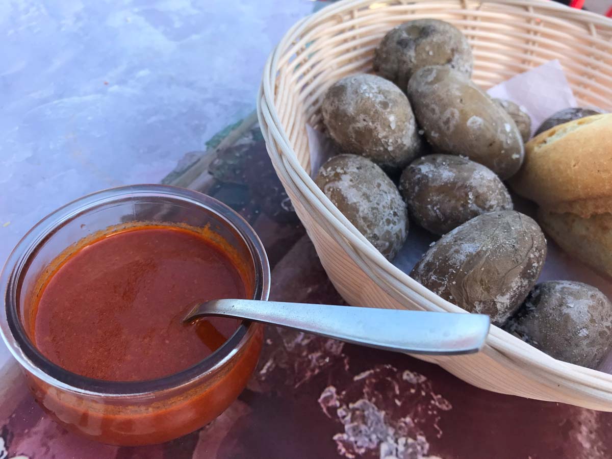 basket of canarian potatoes with bowl of red sauce