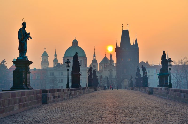 an old stone bridge in prague at sunrise