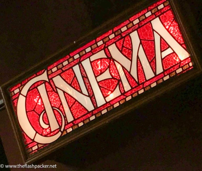 art deco red and beige sign saying cinema