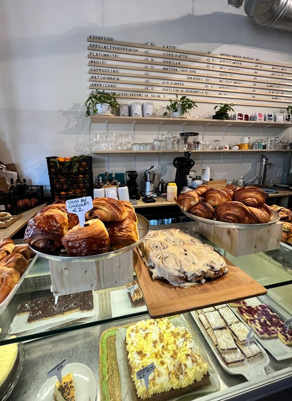 counter at a cafe with pastries and cakes