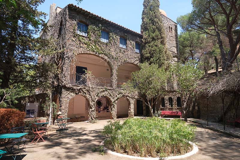 old building house modern art museum in collioure with courtyard and tables and chaisr