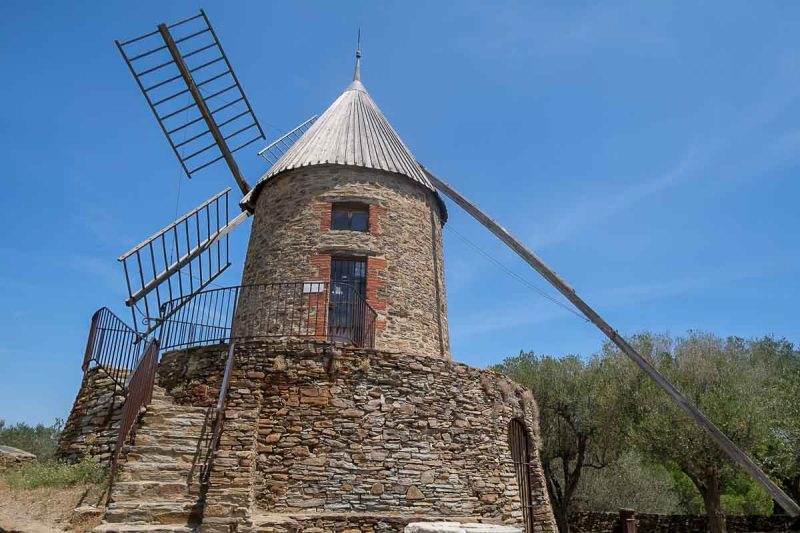 old stone windmill under a blue sky