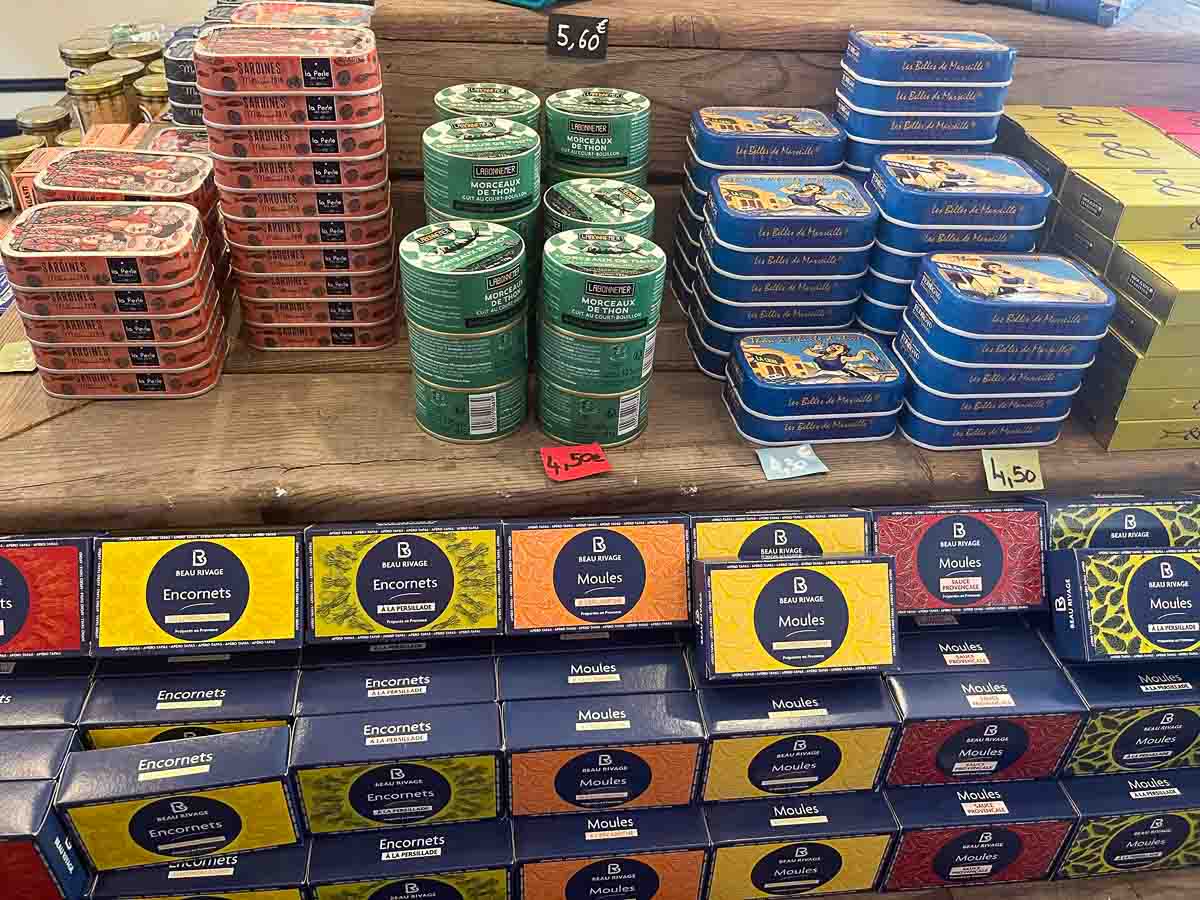 tins and boxes of seafood on a shlf in a shop in collioure