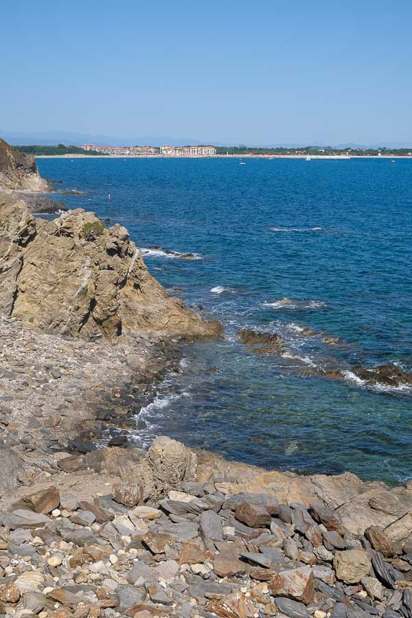 view across a rocky coastline with a small town in the distance