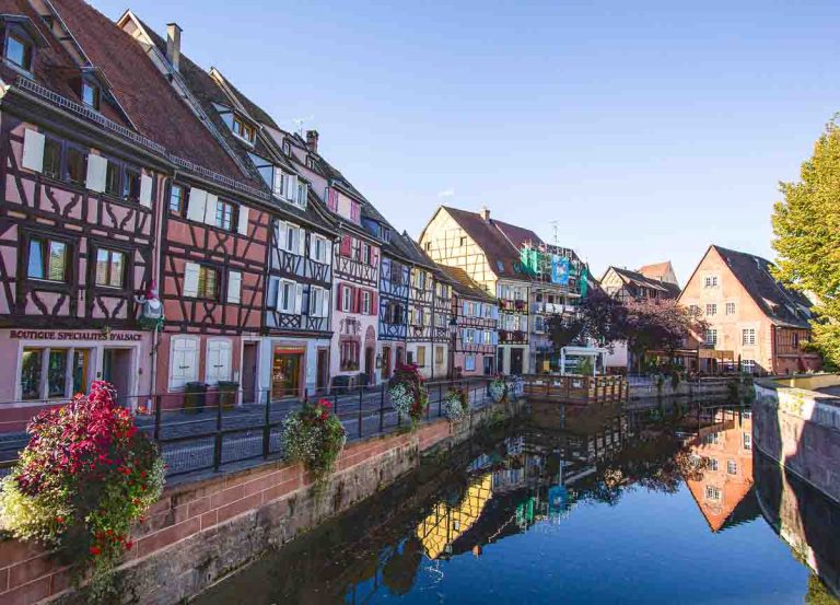 gabled-buidlings reflected in still water of canal in colmar in france