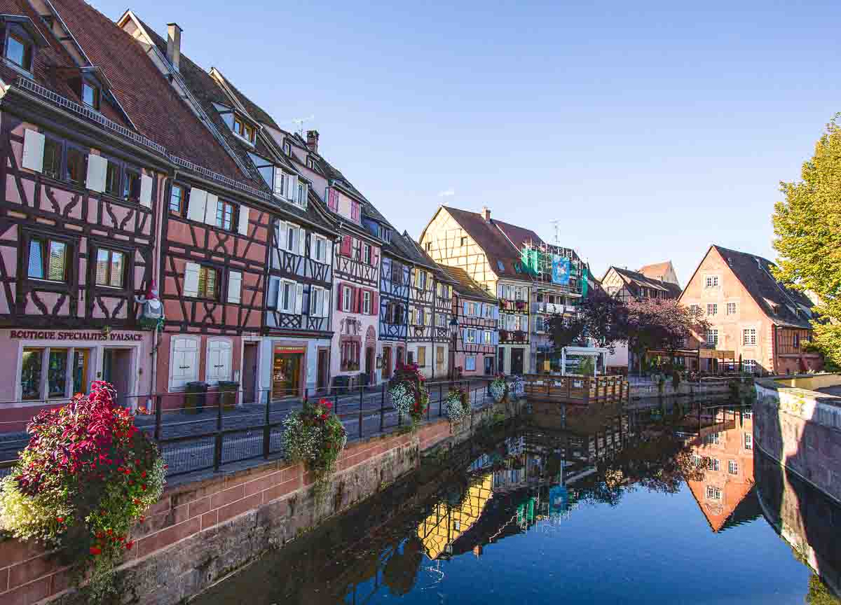 gabled-buildings reflected in still water of canal which are the best things to see in one day in Colmar in France