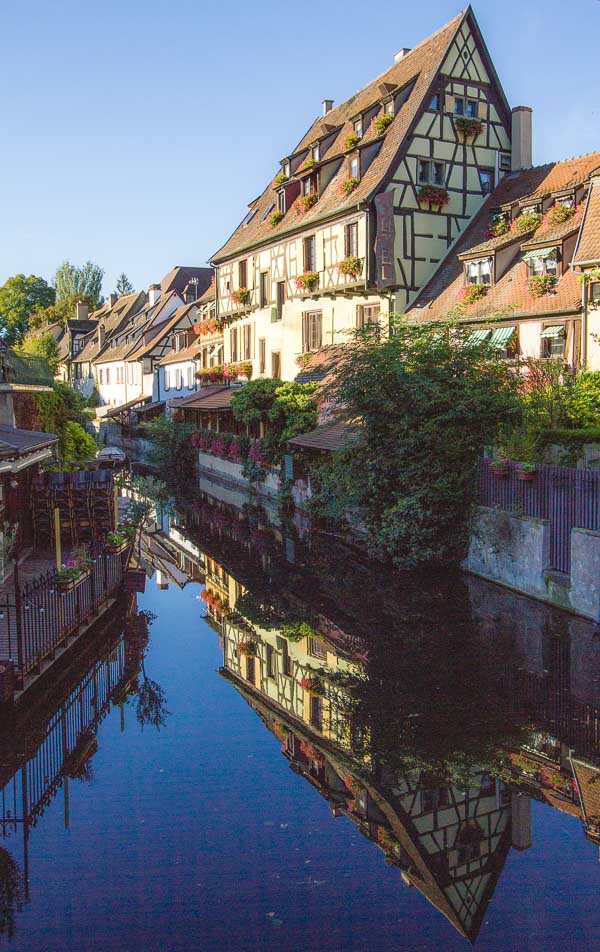 half gabled houses reflected in a canal in colmar in france