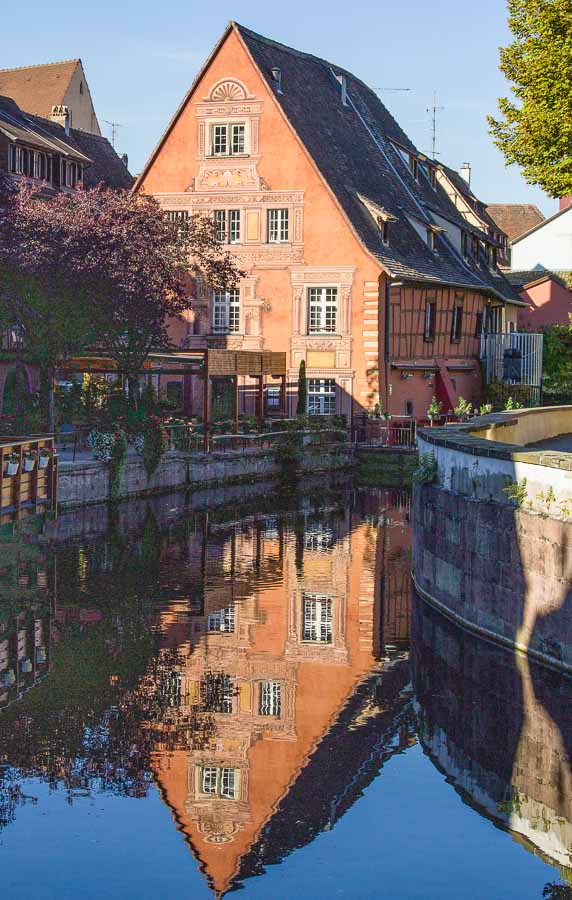 ochre building reflected in blue water