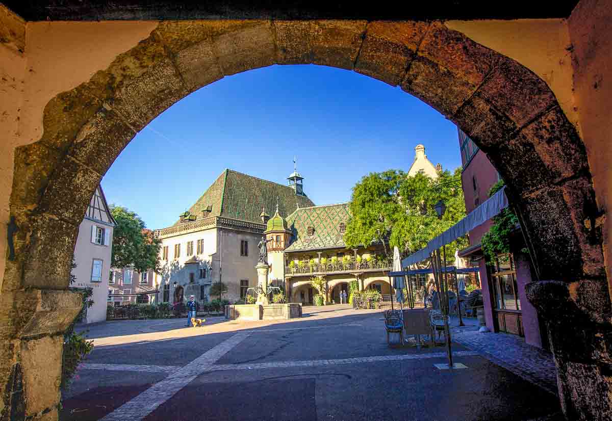 medieval square viewed through stone arch