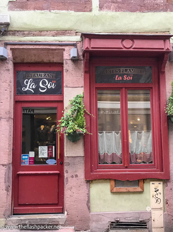 pink and red exterior of la soi restaurant in colmar france