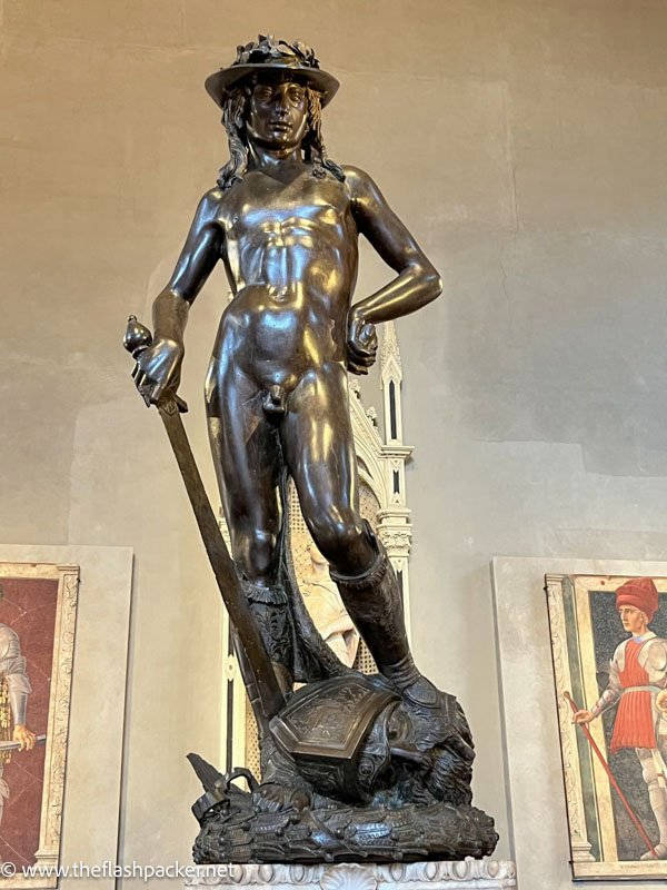 bronze sculpture of a naked david carrying a sword