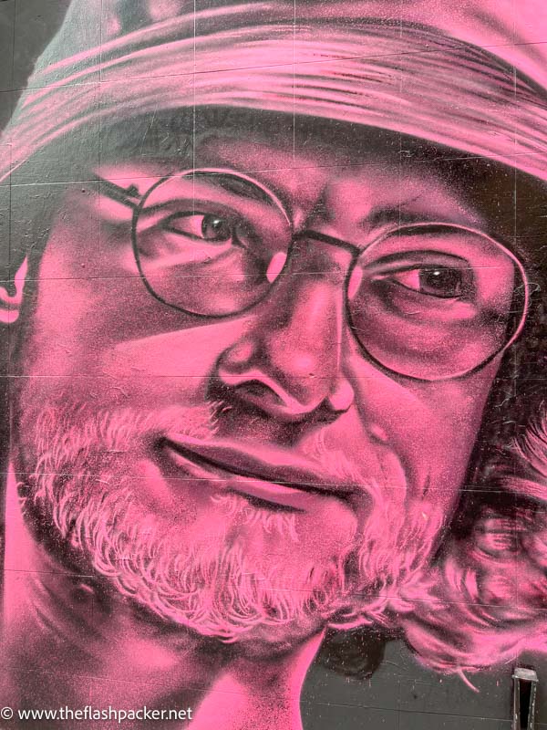 pink and black mural of a man's face