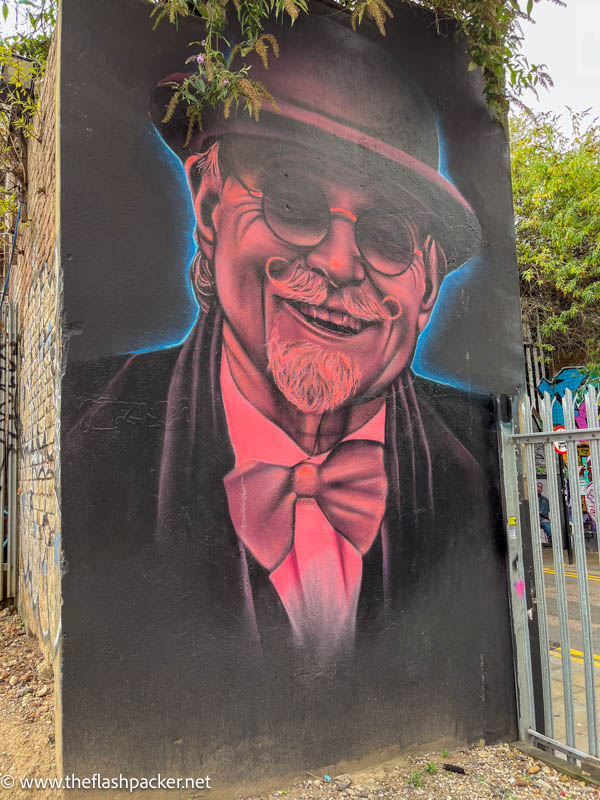 street art of a smiling gentleman wearing a hat and bow tie