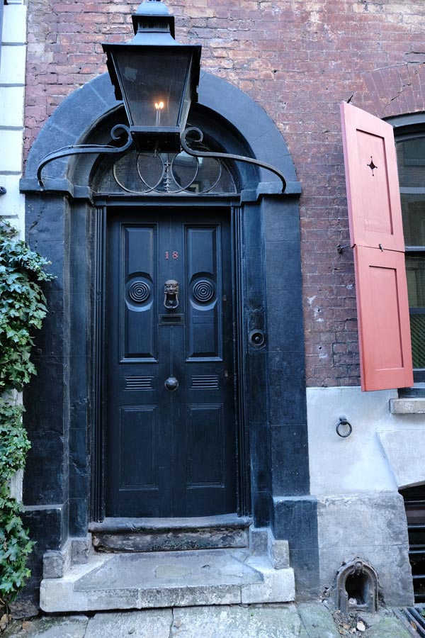 black front door of house with overhead lamp