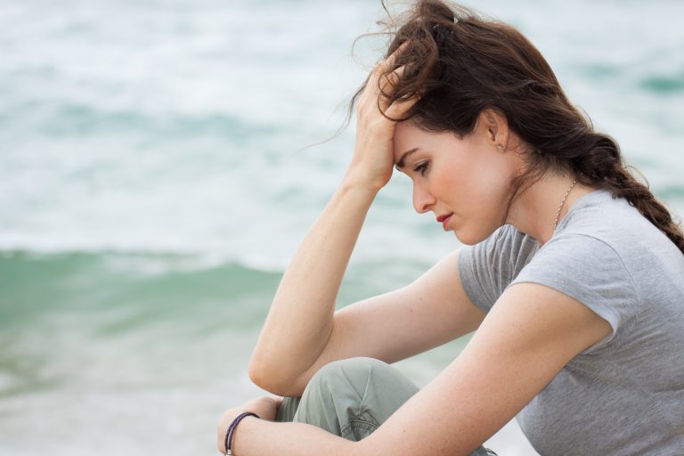 sad and upset woman with her head in her hands