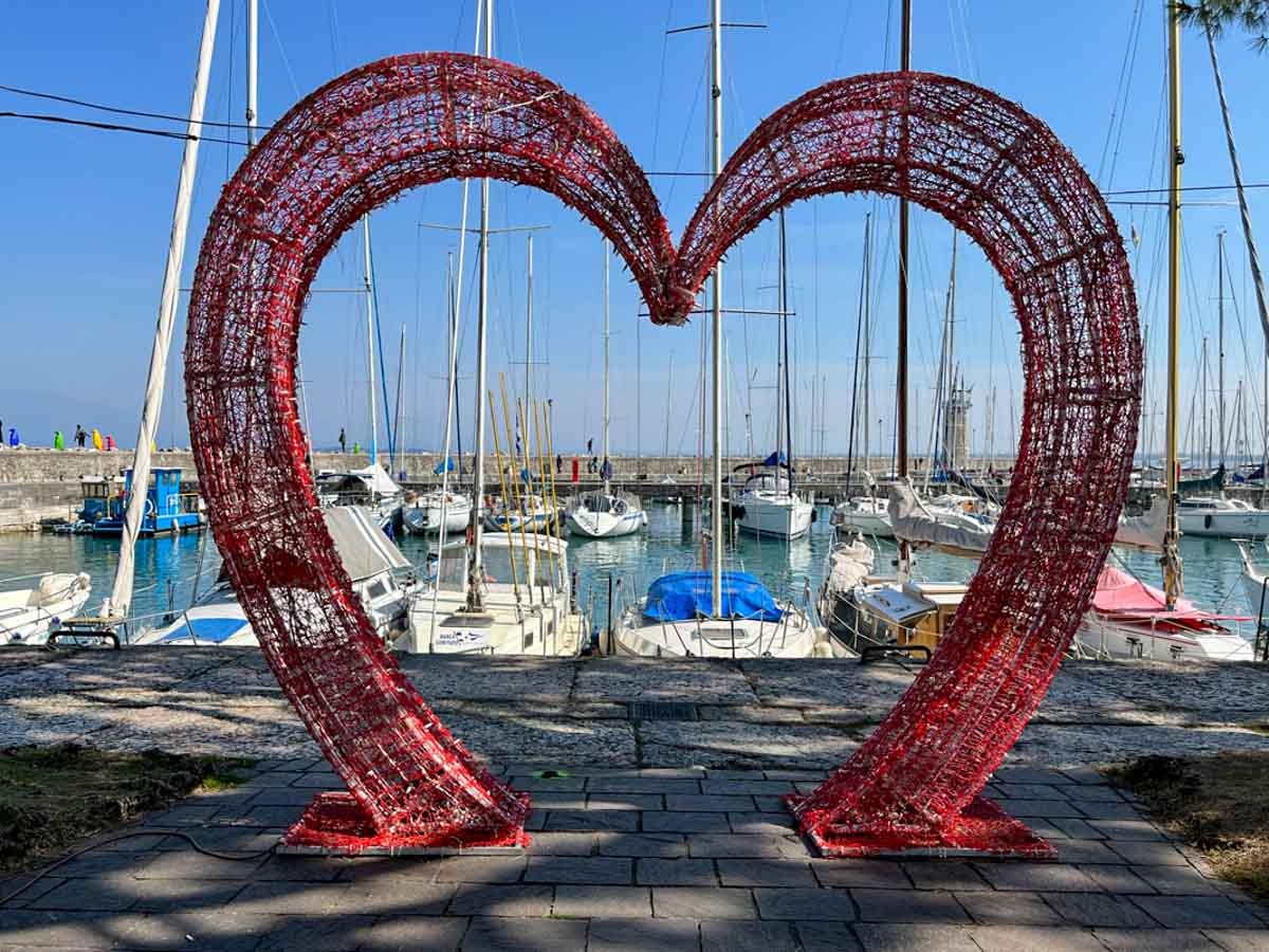 harbour in lake garda viewed through a giant red heart