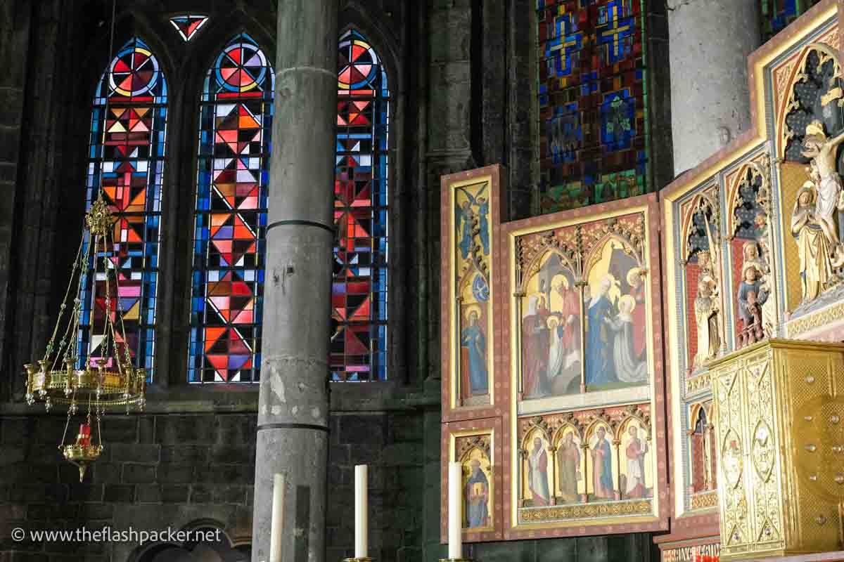 gilded altarpiece and stained glass window in notre dame church in dinant belgium