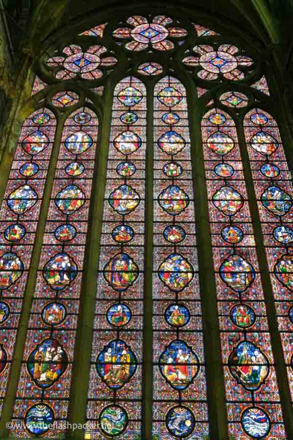 massive stained glass window in a gothic arch