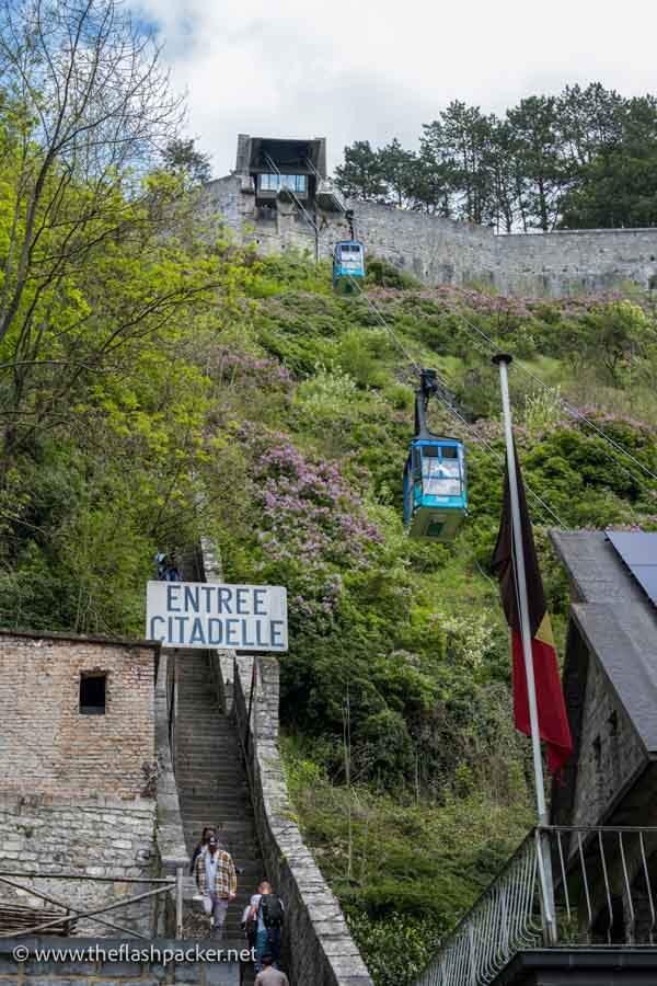 people waling up steps next to a cable car line