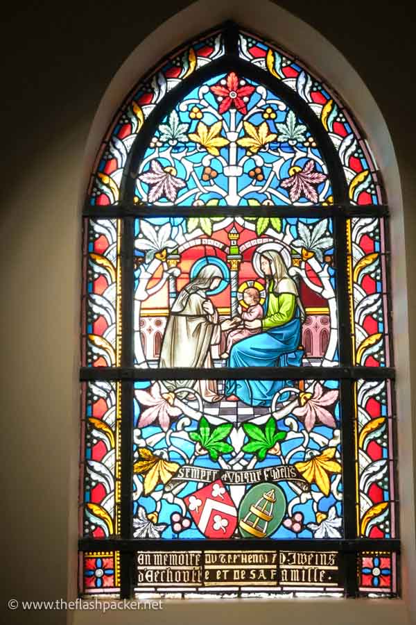 arched stained glass window of madonna and child with another saint