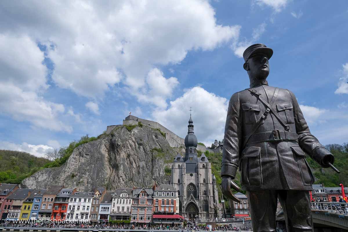 bronze statue of charles de gaulle with brightly coloured buildings and church with onion dome in background