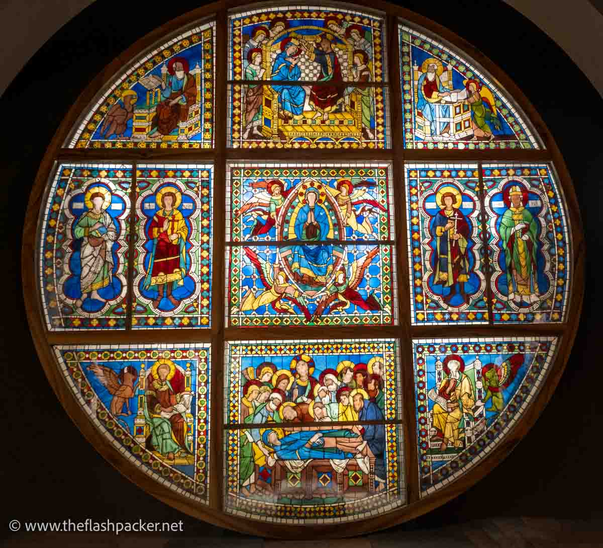 massive circular window with panes of stained glass depicting saints and biblical scenes