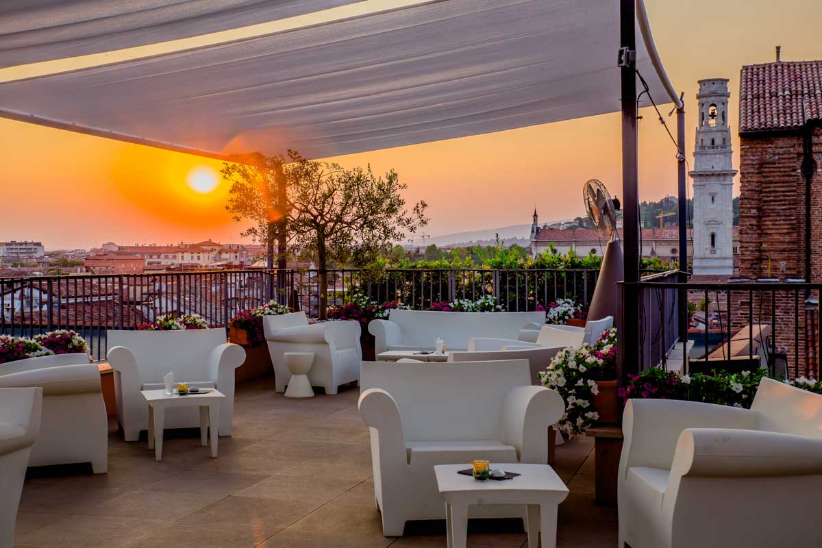 white tables and chairs on a rooftop terrace of a luxury hotel in verona Italy