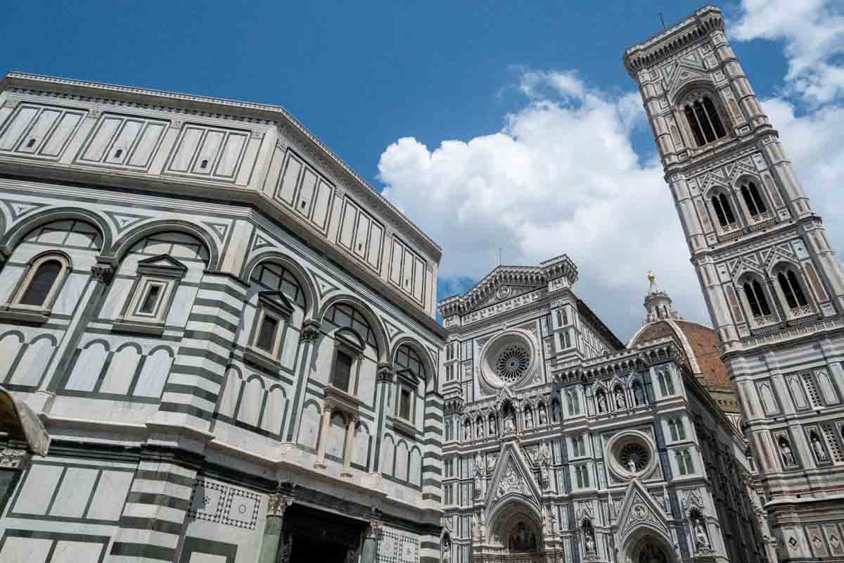 bell tower next to cathedral with red dome and octagonal shaped baptistry building which is one of the best areas to stay in florence italy