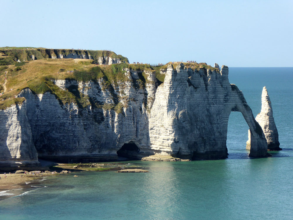 cliffs hewn into a stone arch over ocean in etretat normandy