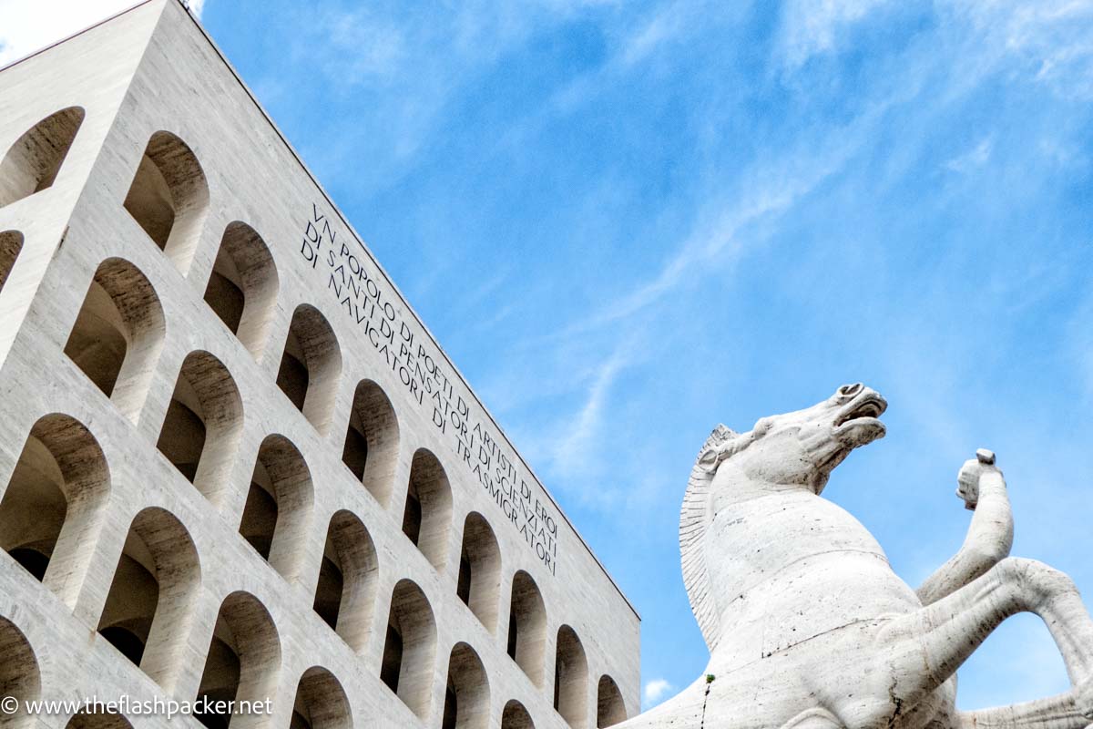 square grey stone building and statue of a horse