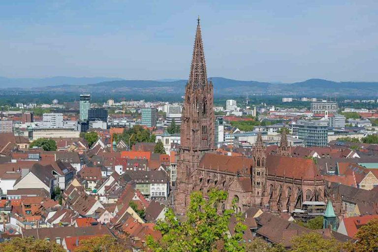 panoramic view of red roofs of Freiburg germany with large sandstone gothic cathedral in centre