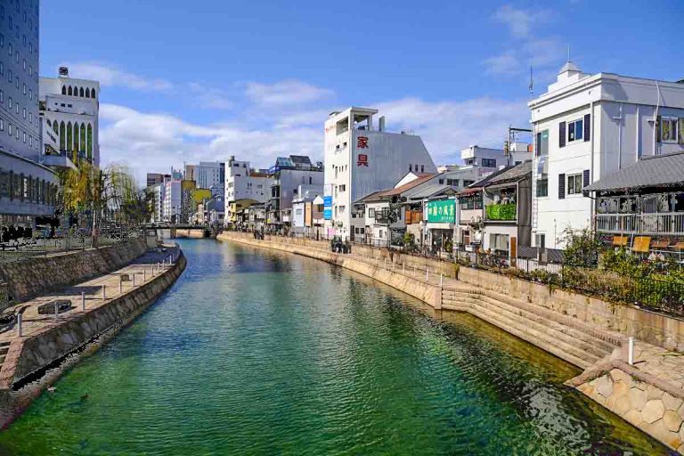 buildings lining the riverfront in fukuoka japan