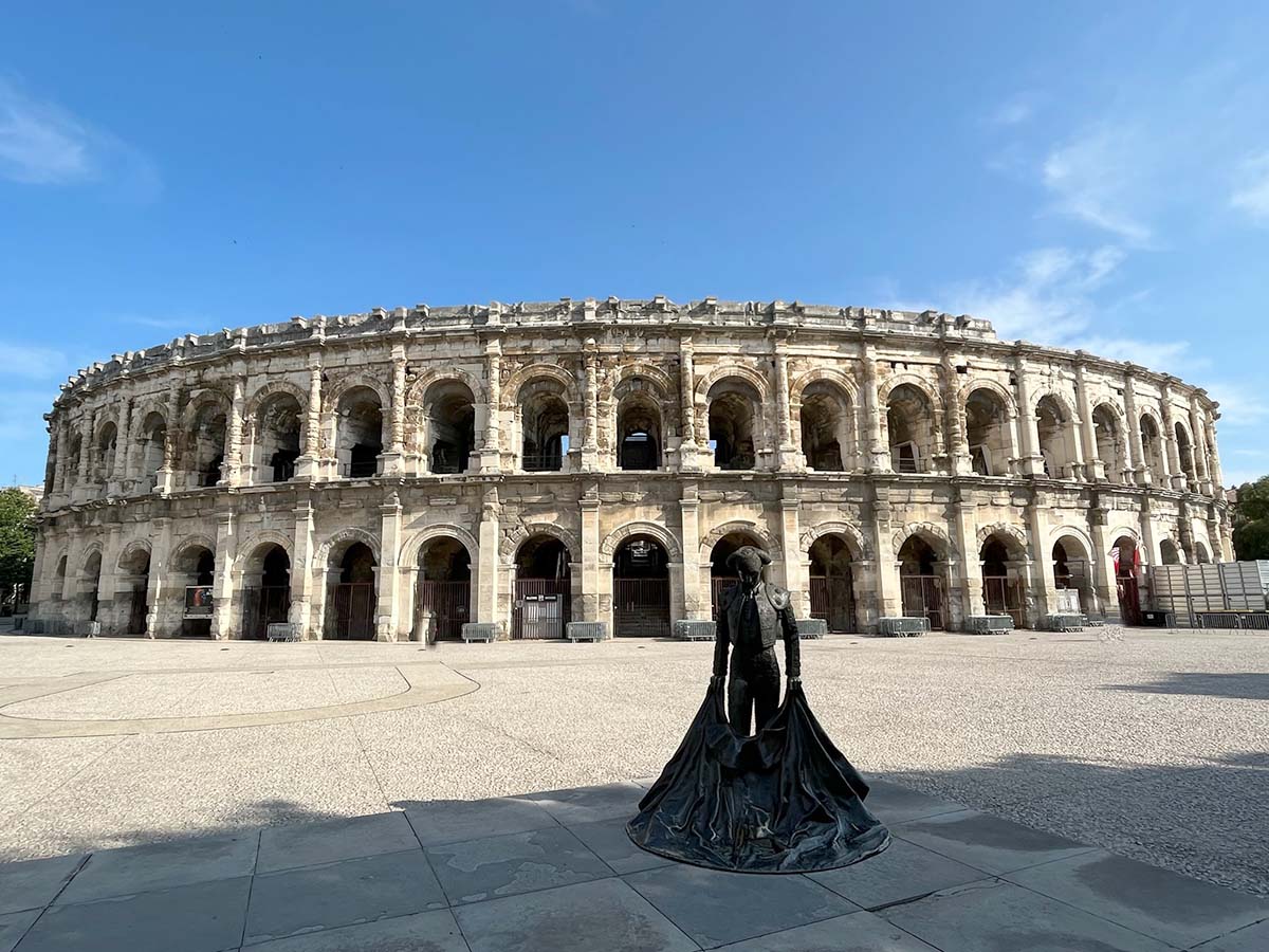 bronze sculpture of a matador in front of the roman arena at nimes in france