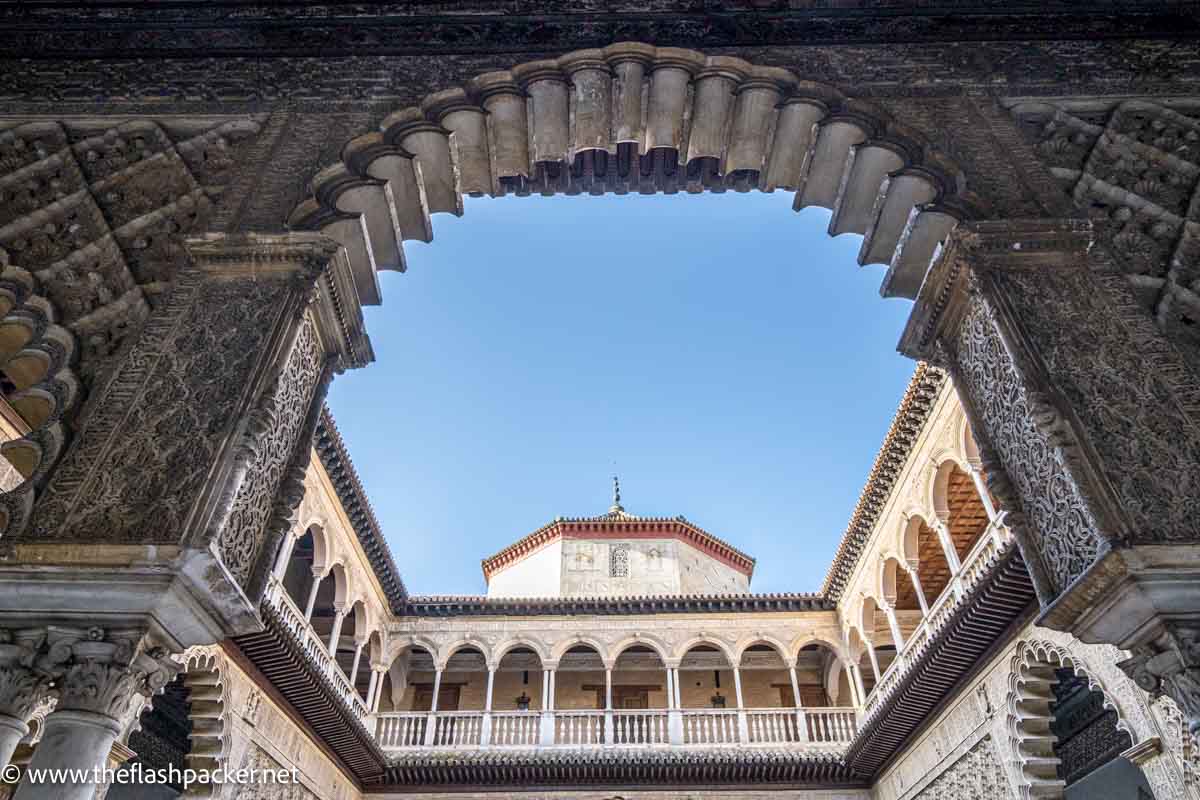 view of colonaded upper level of courtyard through an ornate horseshoe arch