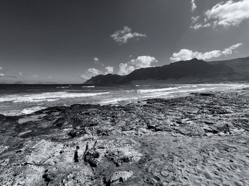 black and white photo of a beach with rock pools