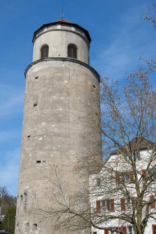 tall cylindrical stone tower against blue sky