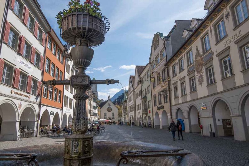 a long narrow medieval market square in feldkirch austria with ornate fountain