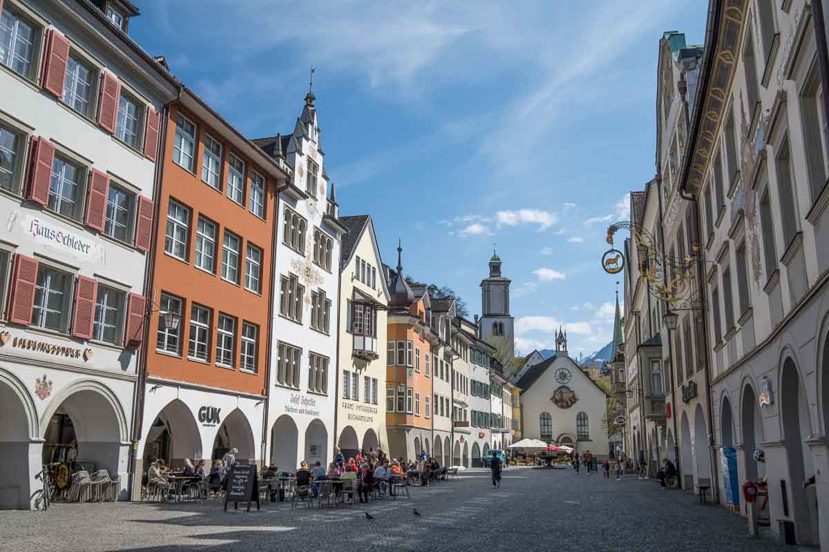 a long narrow medieval market square in feldkirch austria with ornate fountain