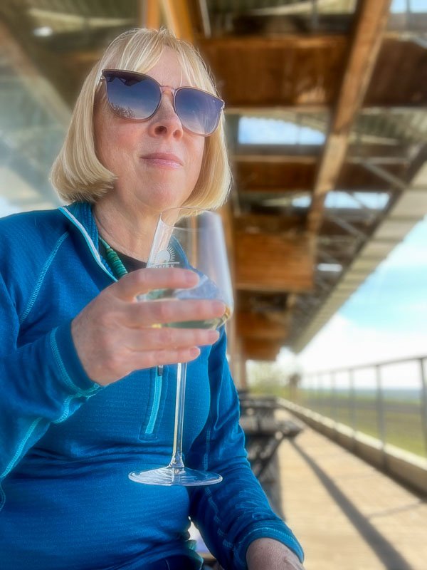 blond woman holding a glass of wine