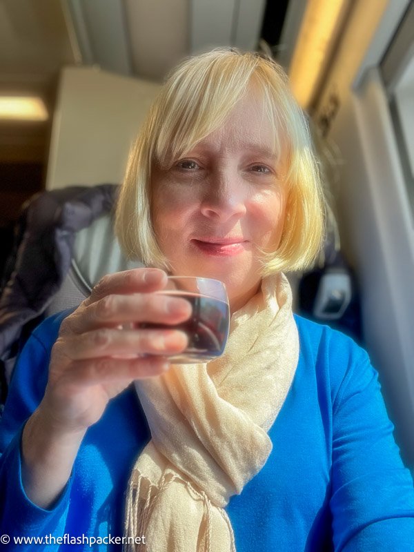 a woman holding up a glass of red wine