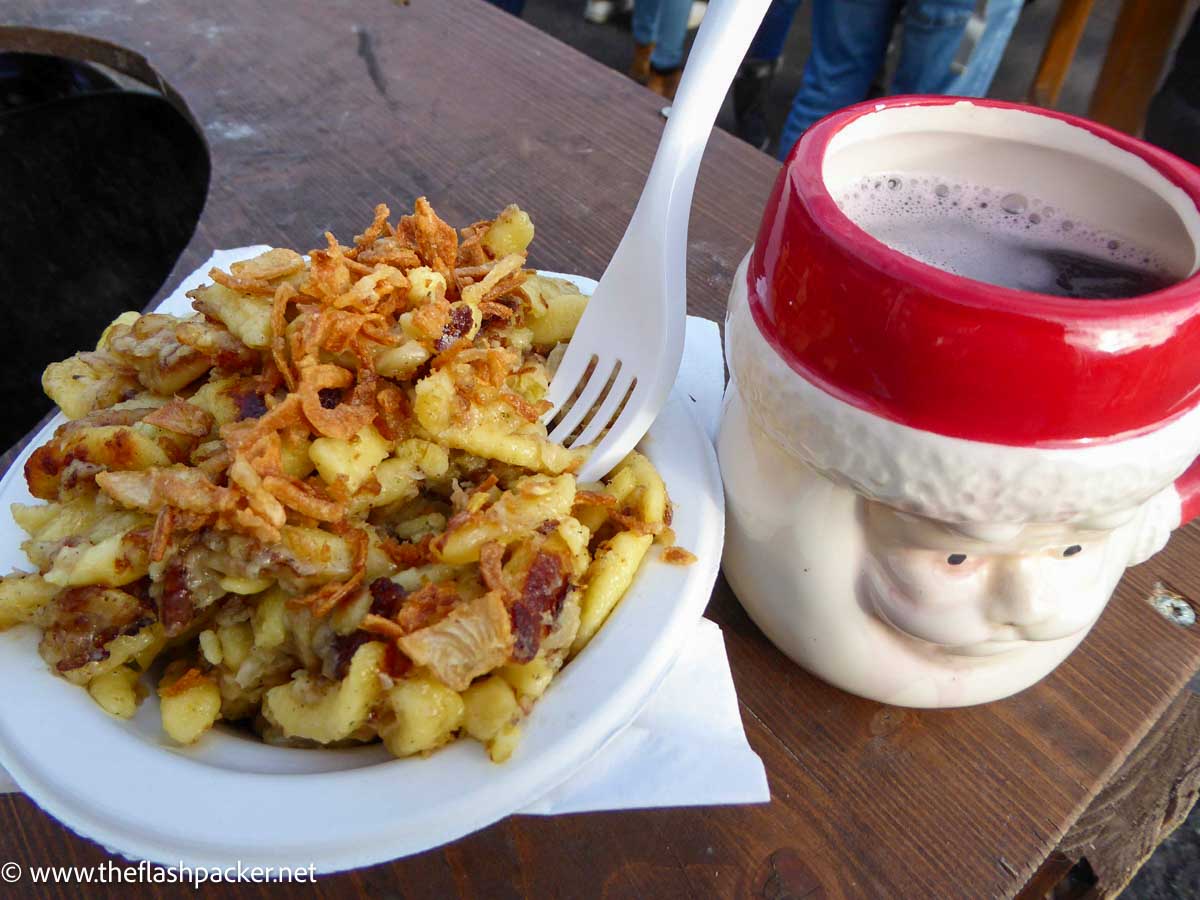 plate of food-at-christmas-market-vienna with mug of mulled wine