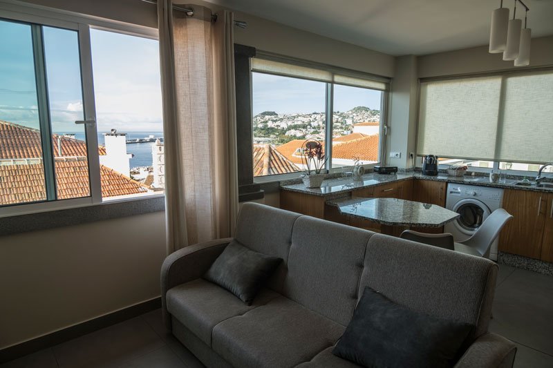 lounge and kitchen of apartment with view of bay outside window