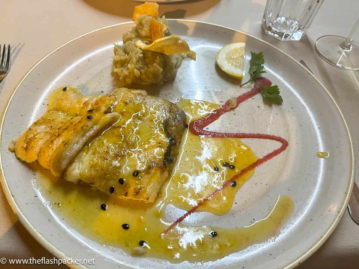 dish of fish covered in a passion fruit sauce