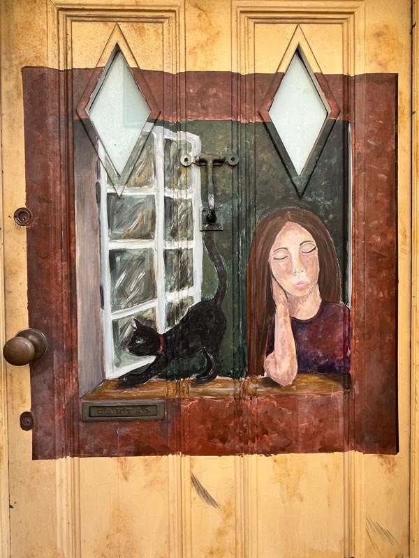 painting of a woman by a window with a black cat