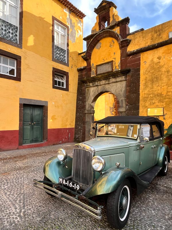 vintage car in courtyard of fortress with yellow walls