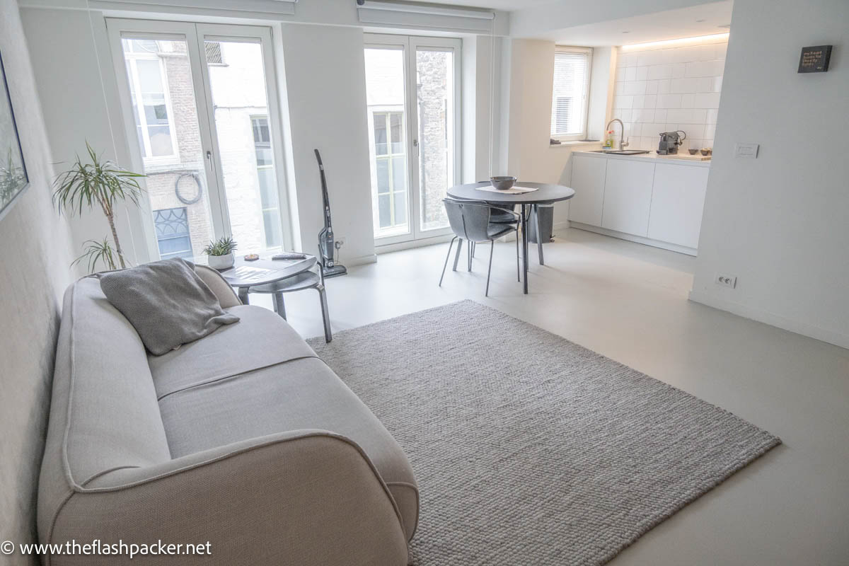 room in a rental apartment with sofa table and chair and kitchenette